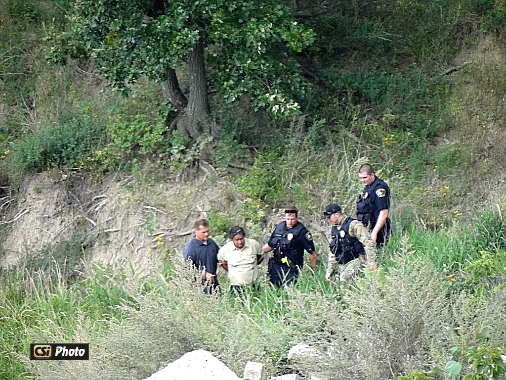 Law enforcement remove suspect from where he was hiding. 